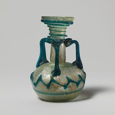 a green and blue vase sitting on top of a table