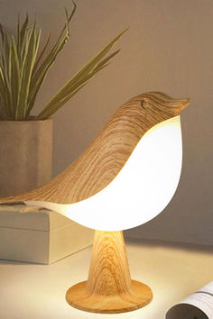 a wooden bird lamp sitting on top of a table