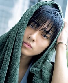 a young man wearing a green towel around his head