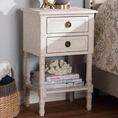 a nightstand with a clock on top of it next to a bed and a wicker basket