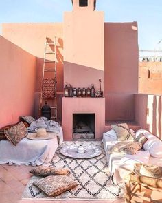 a living room with a fire place and lots of pillows