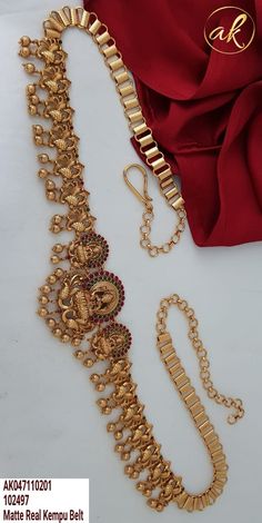 the gold necklace is laying on top of a red cloth