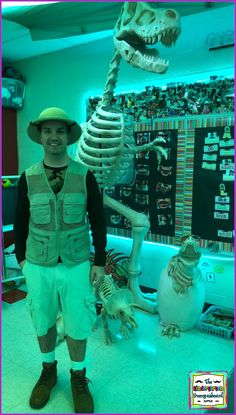 a man standing in front of a fake dinosaur skeleton