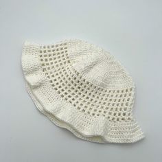 a white knitted hat with holes on the front and side, sitting on top of a table