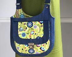 a blue and yellow purse hanging from the back of a woman's green dress