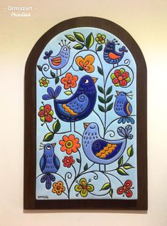 a colorful stained glass window with two birds and flowers on it's side, hanging from the wall