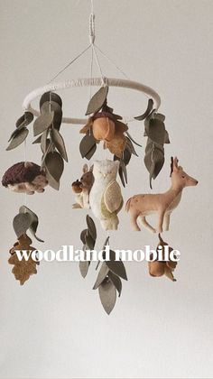 a mobile with animals and leaves hanging from it's sides that says woodland mobile