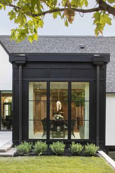 a black and white house with glass doors