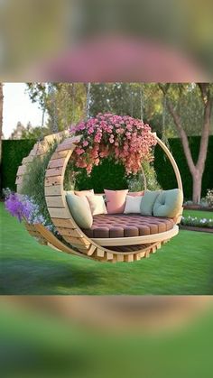 an outdoor swing bed with flowers hanging from it's sides and pillows on the back