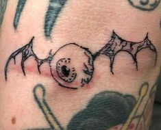 a close up of a person's leg with tattoos on it and bats around the legs