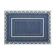 a blue rug with white border on the bottom and an embroidered border in the middle