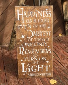 a wooden sign that says happiness can be found even in the dark