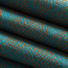 an orange and teal colored fabric with small squares on the top, in diagonal rows