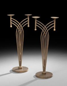 three metal candlesticks are standing next to each other