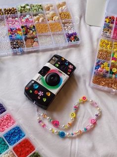 a camera sitting on top of a white table covered in lots of beads and beads