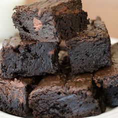 chocolate brownies stacked on top of each other with a glass of milk in the background