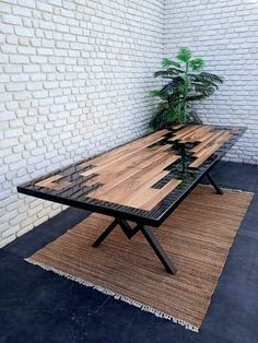 a wooden table sitting on top of a rug next to a white brick wall and potted plant