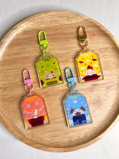 four luggage tags with animals on them sitting on top of a wooden tray in front of a white wall