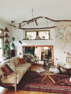 a living room filled with furniture and a fire place next to a wall covered in plants