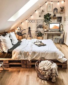 an attic bedroom is decorated in white and wood with string lights strung above the bed