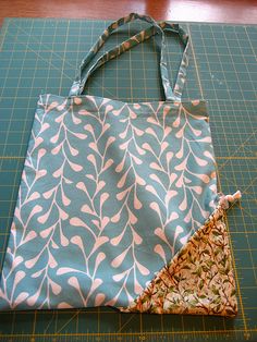 a bag sitting on top of a cutting board next to a piece of cloth and scissors