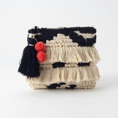 a purse with tassels and pompoms hanging from it