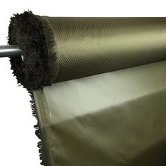 a roll of green fabric with fringes on the end and one piece of metal rod attached to it