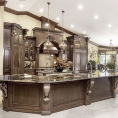 a large kitchen with marble counter tops and wooden cabinets, along with an island in the middle