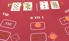 a red table topped with playing cards and dice