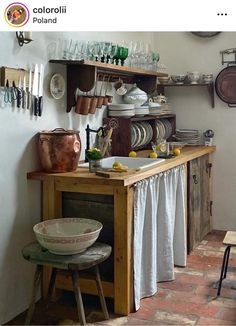 an old fashioned kitchen with lots of dishes on the counter