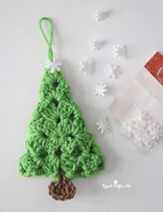 a crocheted christmas tree ornament with snowflakes around it