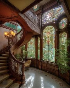 an ornate staircase with stained glass windows and wooden railings, along with potted plants