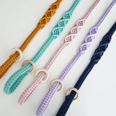 four different colors of braided bracelets with rings on each side and an o - ring at the end