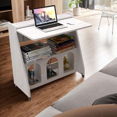 a laptop computer sitting on top of a white table next to a couch in a living room