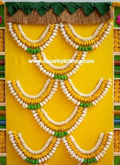the wall is decorated with white and green beads on yellow fabric, along with other decorative items