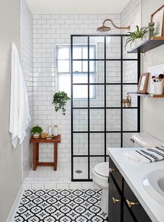 a white tiled bathroom with black and white accents