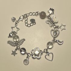 a close up of a bracelet with charms and heart shaped items on the clasps