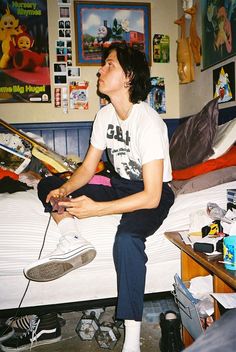 a woman sitting on top of a bed in a bedroom