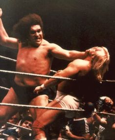 two men wrestling in a ring surrounded by spectators