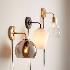 three light fixtures mounted on the wall with one bulb turned upside down and two lights attached to each other