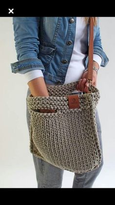 a woman holding a knitted purse in her hands