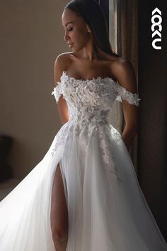 a woman in a white wedding dress posing with her leg on the floor and wearing high heels