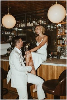 a man and woman sitting at a bar