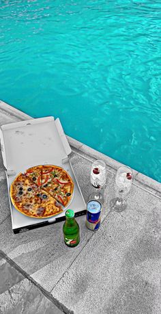a pizza sitting on top of a white box next to a pool filled with water