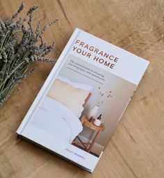 a book sitting on top of a wooden table next to a vase filled with flowers