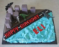 a birthday cake that is shaped to look like a highway with cars and dinosaurs on it