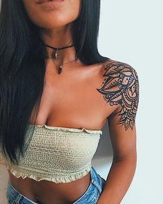 a woman with long black hair and tattoos on her arm