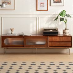 a living room with pictures on the wall and a record player in front of it