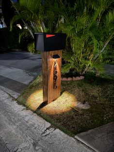 a mailbox sitting on the side of a road at night