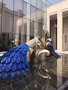 a peacock statue sitting in front of a building